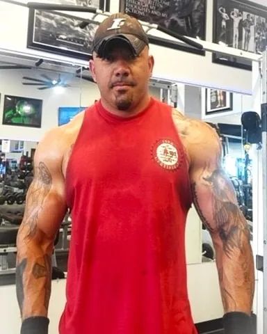 Shane Dickey in a red tank top and cap on the gym floor